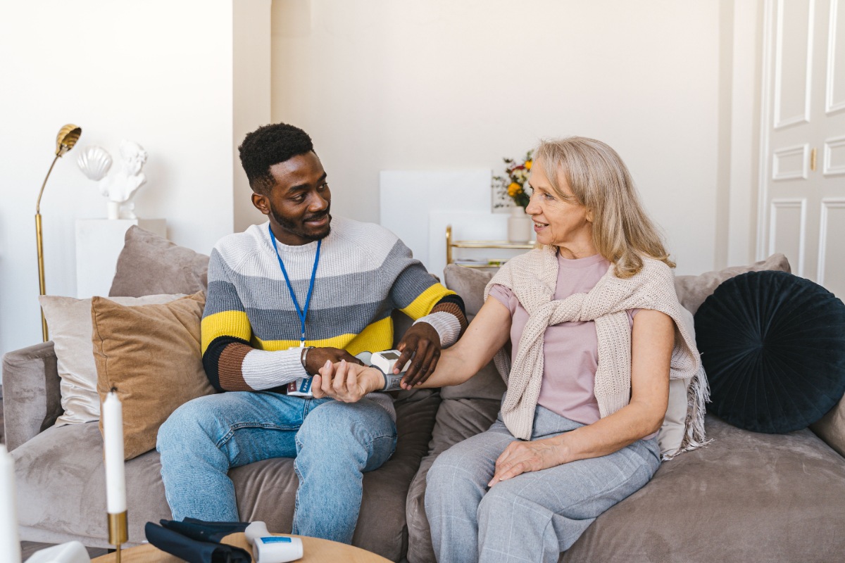 Friendly caregiver sitting with a senior woman at home, providing compassionate in-home care in Paoli, IN