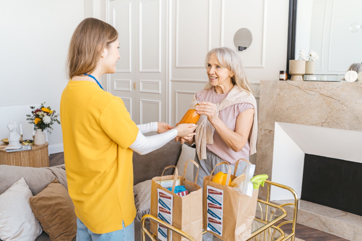 Compassionate caregiver assisting an elderly woman in her home in Paoli, IN