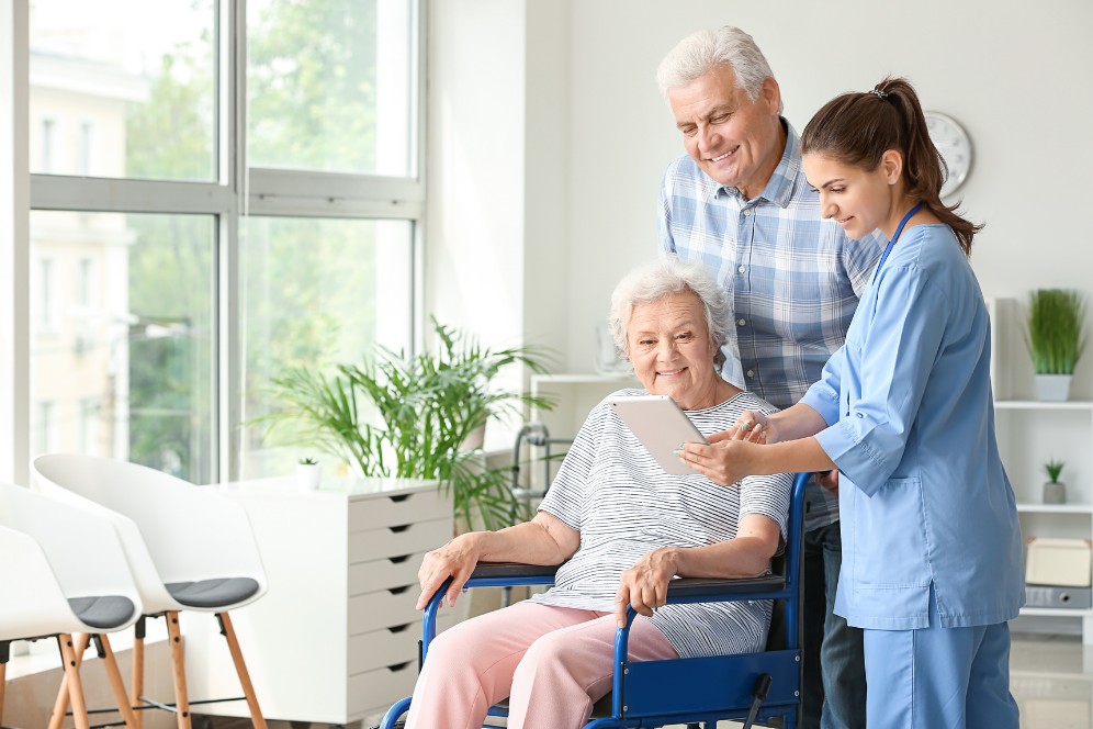 Senior woman in wheelchair receiving compassionate home care support from a caregiver and family member in Indianapolis